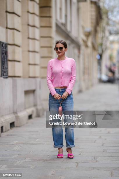 Diane Batoukina @diaanebt wears brown sunglasses from Dior, a pink wool buttoned cardigan from Mango, a silver Love ring from Cartier, blue faded...