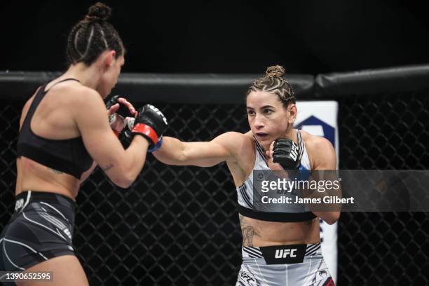 Tecia Torres punches Mackenzie Dern in their strawweight fight during the UFC 273 event at VyStar Veterans Memorial Arena on April 09, 2022 in...