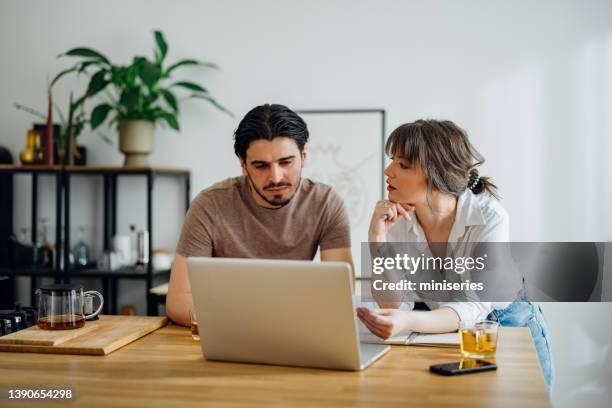 serious couple paying bills at home - husband stock pictures, royalty-free photos & images