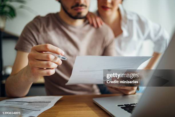 unrecognizable couple paying bills at home - energy bills stock pictures, royalty-free photos & images