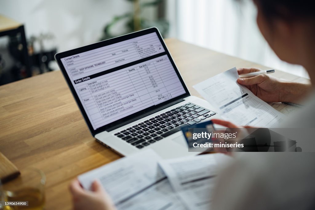 Unrecognizable Couple Paying Bills at Home