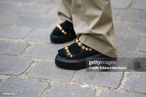 Natalia Verza @mascarada.paris wears beige large flared pants, black shiny leather with embroidered gold metallic pearls strappy / platform soles...