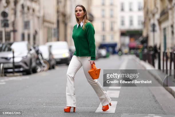 Maria Rosaria Rizzo @lacoquetteitalienne wears white pearl earrings, a shirt, high waist with silver buttoned / white latte denim / flared pants, a...