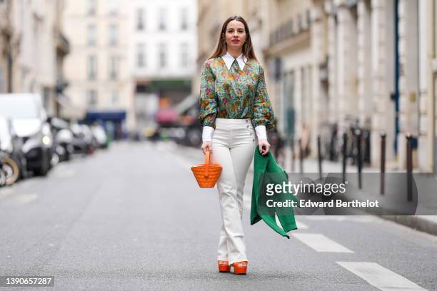 Maria Rosaria Rizzo @lacoquetteitalienne wears white pearl earrings, a pale blue with green / orange / purple flower print pattern shirt, high waist...