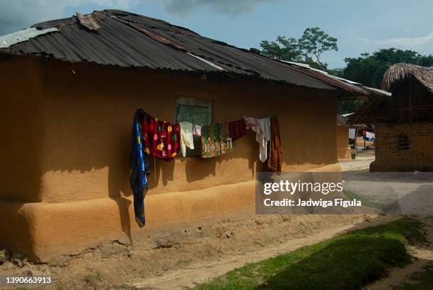 clothes hang on the washing line to dry in a remote village in liberia. - マッドハット ストックフォトと画像