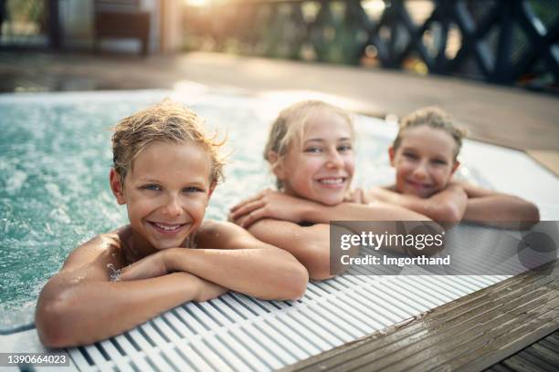 três crianças curtindo banheira de jacuzzi ao ar livre no quintal - girls in hot tub - fotografias e filmes do acervo