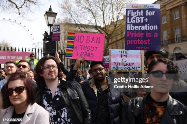 Demonstrators hold placards during the No Ban Without Trans protest opposite Downing Street on April 10, 2022 in London, England. LGBTQ+ collectives...