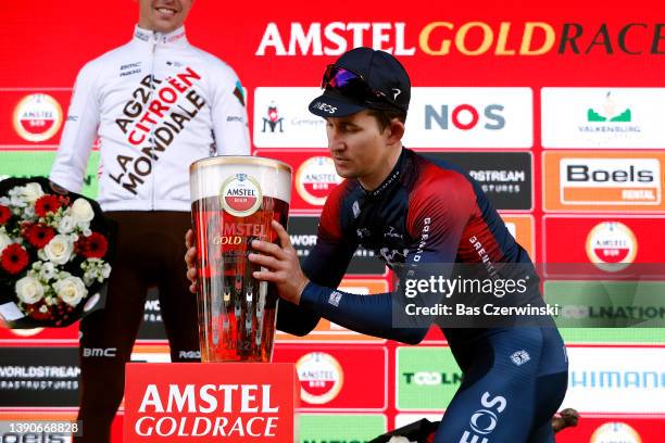Michal Kwiatkowski of Poland and Team INEOS Grenadiers grabs his beer to celebrates winning the race on the podium ceremony after the 56th Amstel...