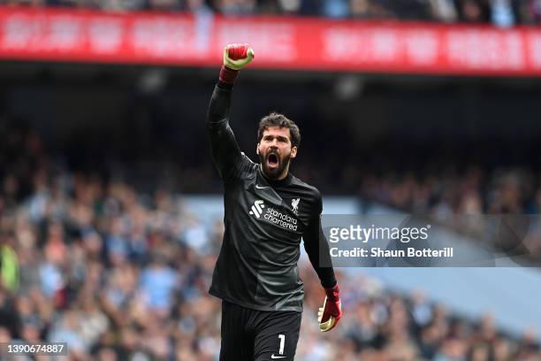 Alisson Becker of Liverpool celebrates their side's first goal scored by Diogo Jota of Liverpool during the Premier League match between Manchester...