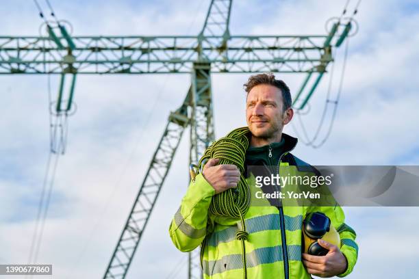 portrait of an electrical engineer in front of high voltage power transformer substation - 電源纜 個照片及圖片檔