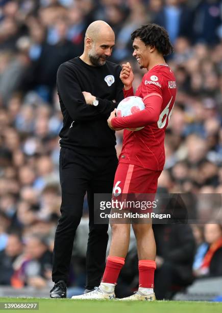 Trent Alexander-Arnold of Liverpool and Pep Guardiola, Manager of Manchester City share a joke during the Premier League match between Manchester...