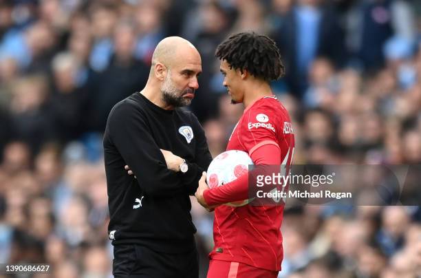Trent Alexander-Arnold of Liverpool and Pep Guardiola, Manager of Manchester City share a joke during the Premier League match between Manchester...