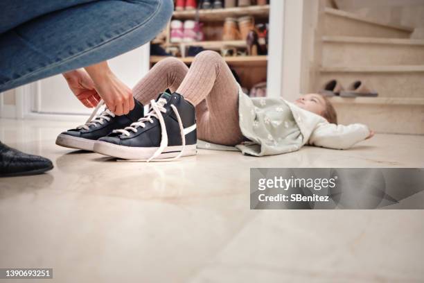 mother putting her little daughter's slippers on - kid in big shoes stock pictures, royalty-free photos & images
