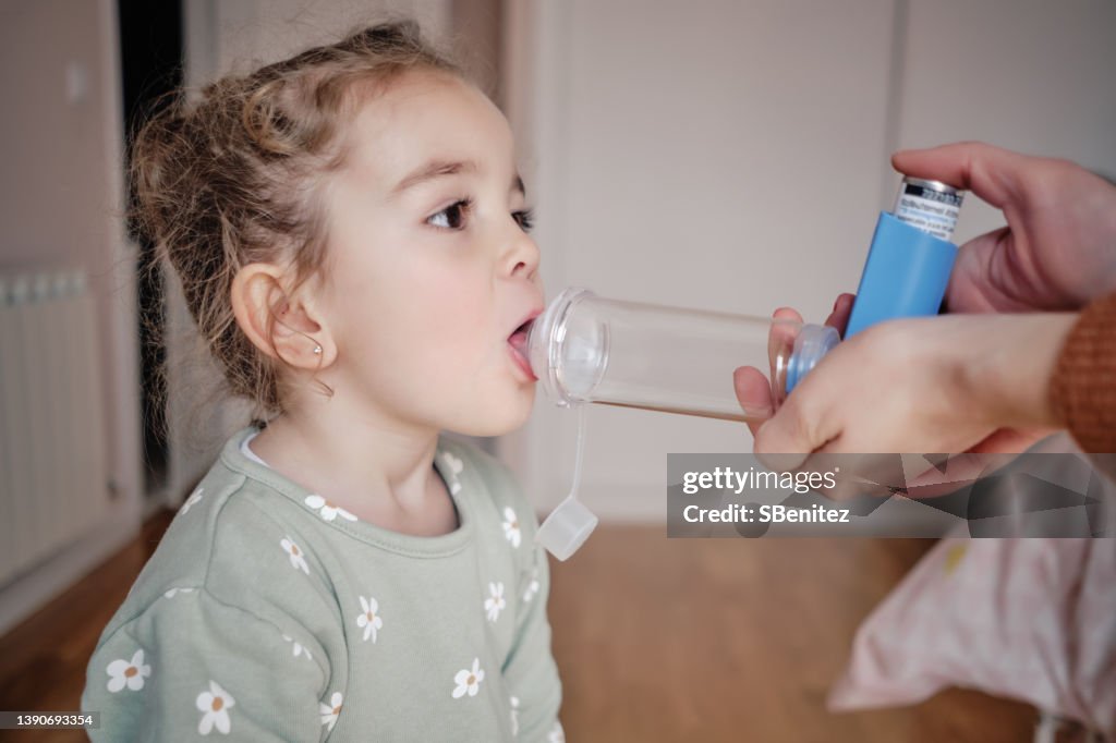 Young girl receiving respiratory treatment at home