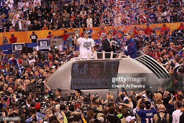 Quarterback Eli Manning of the New York Giants celebrates the victory by lifting the Lombardi Trophy after a win against the New England Patriots in...