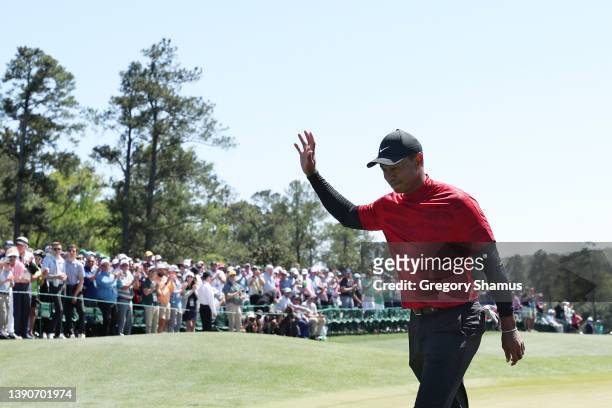Tiger Woods waves to the crowd on the 18th green after finishing his round during the final round of the Masters at Augusta National Golf Club on...