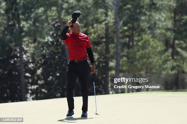 Tiger Woods tips his hat to the crowd on the 18th green after finishing his round during the final round of the Masters at Augusta National Golf Club...