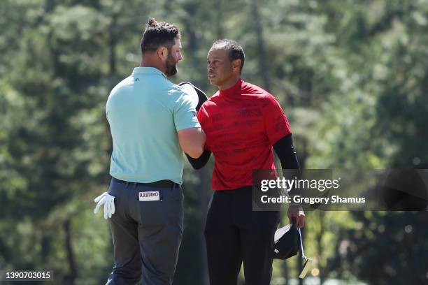 Jon Rahm of Spain and Tiger Woods shake hands on the 18th green after finishing their round during the final round of the Masters at Augusta National...