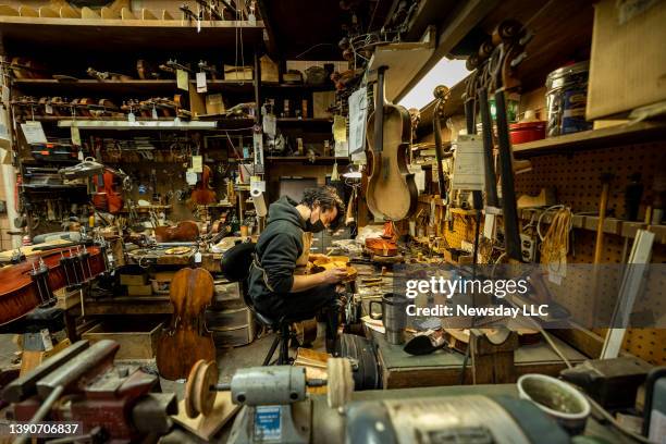 Rigo Dubon repairs violins at Kolstein Music in Baldwin, New York on Feb. 16, 2022.