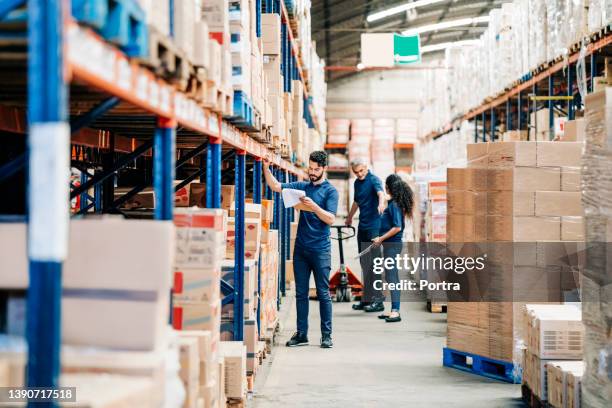 personnes travaillant dans un grand entrepôt de distribution - hangar photos et images de collection
