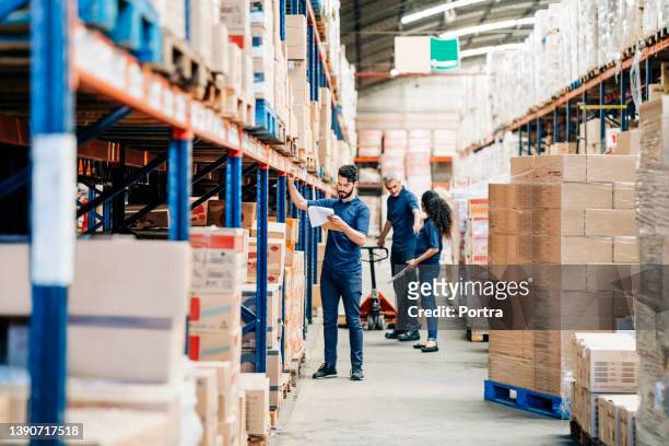 people working in a large distribution warehouse - wholesale stockfoto's en -beelden