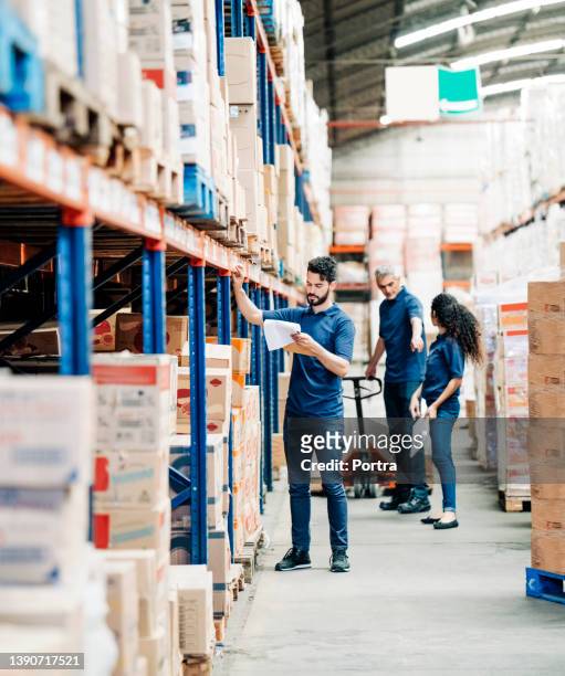 trabajador del almacén de distribución que verifica el inventario en los estantes de almacenamiento - hardware store fotografías e imágenes de stock