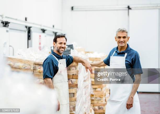 portrait of two happy butchers working at meat packaging warehouse - frys bildbanksfoton och bilder