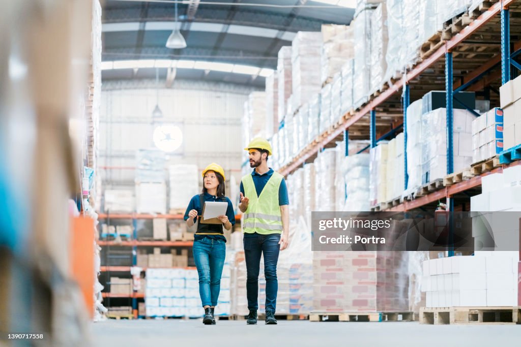 Deux employés vérifiant les stocks sur les rayonnages d’entrepôt