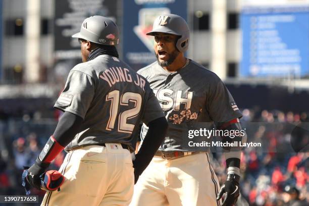 Nelson Cruz of the Washington Nationals celebrates singling in two runs in the eighth inning with first base coach Eric Young Jr. #12 during a...