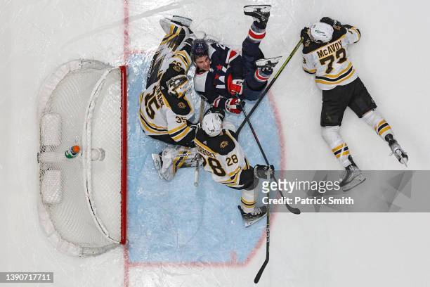 Garnet Hathaway of the Washington Capitals collides with goalie Linus Ullmark of the Boston Bruins during the second period at Capital One Arena on...