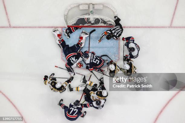 Goalie Vitek Vanecek of the Washington Capitals makes a save as teammates and Boston Bruins players crash the net during the first period at Capital...