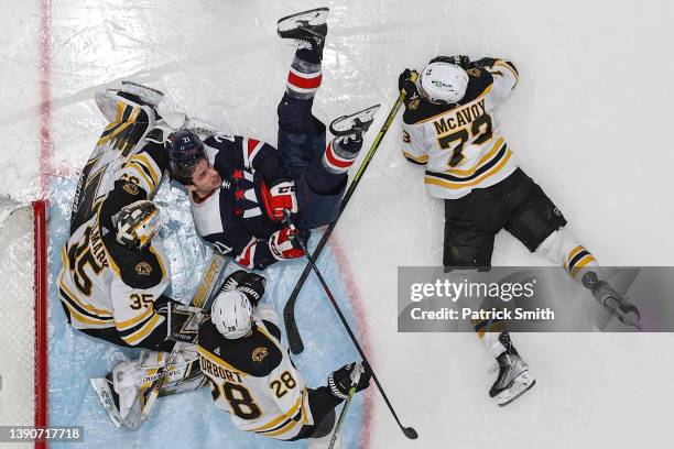 Garnet Hathaway of the Washington Capitals collides with goalie Linus Ullmark of the Boston Bruins during the second period at Capital One Arena on...