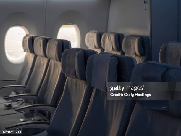 rows of empty seats in a modern scandinavian clean design airplane cabin interior as airlines struggle to battle low passenger numbers post covid and due to inflation price rises in the aviation sector - siège d'avion photos et images de collection