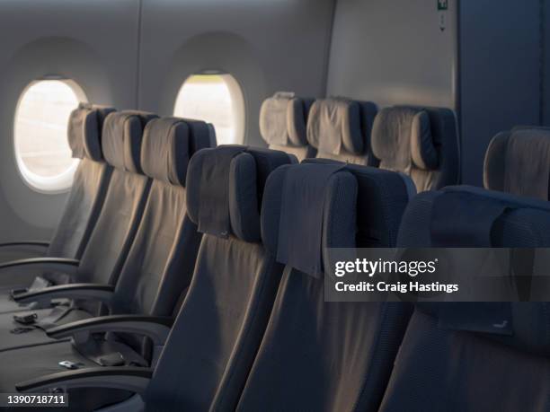 rows of empty seats in a modern scandinavian clean design airplane cabin interior as airlines struggle to battle low passenger numbers post covid and due to inflation price rises in the aviation sector - vliegtuigstoel stockfoto's en -beelden