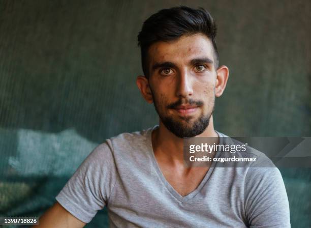 junges jugendliches männerporträt, blick in die kamera - flüchtlingslager türkei stock-fotos und bilder