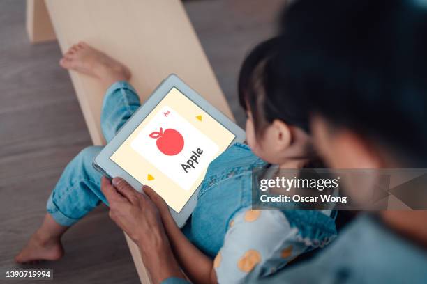 young girl learning with digital tablet together with her father - child and ipad stockfoto's en -beelden