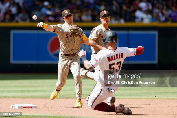 Infielder Jake Cronenworth of the San Diego Padres throws over the sliding Christian Walker of the Arizona Diamondbacks to complete a double play...