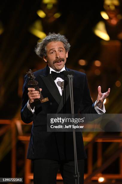 Elliot Levey on stage accepting his award for Best Actor in a Supporting Role in a Musical for "Cabaret"during The Olivier Awards 2022 with...
