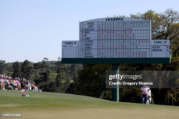 Rory McIlroy of Northern Ireland plays his shot from the bunker on the 18th green as Collin Morikawa looks on during the final round of the Masters...