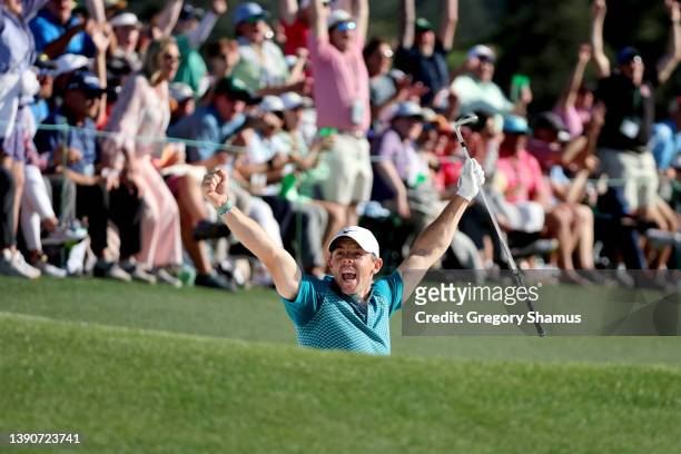 Rory McIlroy of Northern Ireland reacts after chipping in for birdie from the bunker on the 18th green during the final round of the Masters at...