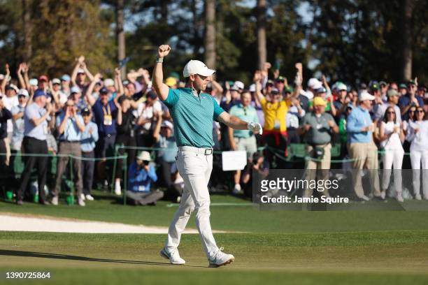 Rory McIlroy of Northern Ireland reacts after chipping in for birdie from the bunker on the 18th green during the final round of the Masters at...