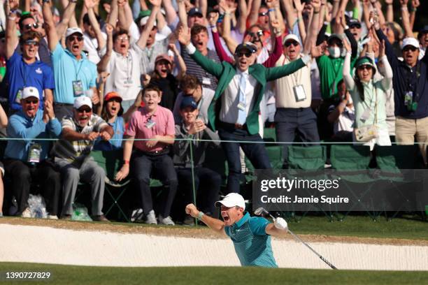 Rory McIlroy of Northern Ireland reacts after chipping in for birdie from the bunker on the 18th green during the final round of the Masters at...