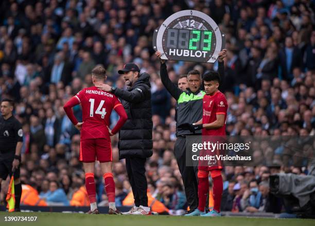 Liverpool manager Jurgen Klopp talks to Jordan Henderson while Luis Diaz waits to come on as a substitute during the Premier League match between...