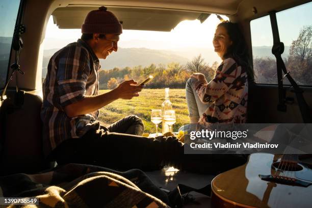 a young couple enjoying some quality time together in their camper van - camping van stock pictures, royalty-free photos & images