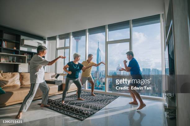 asian chinese senior man teaching his senior friends tai chi enjoying home workout during evening in apartment living room - tai chi shadow stock pictures, royalty-free photos & images