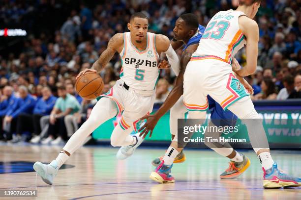 Dejounte Murray of the San Antonio Spurs drives around a pick set by Zach Collins as Dorian Finney-Smith of the Dallas Mavericks defends in the first...