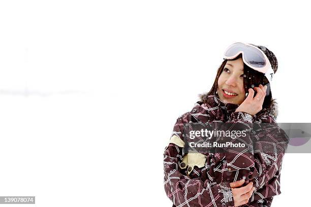 young woman using mobile phone in snow - ski wear stock pictures, royalty-free photos & images