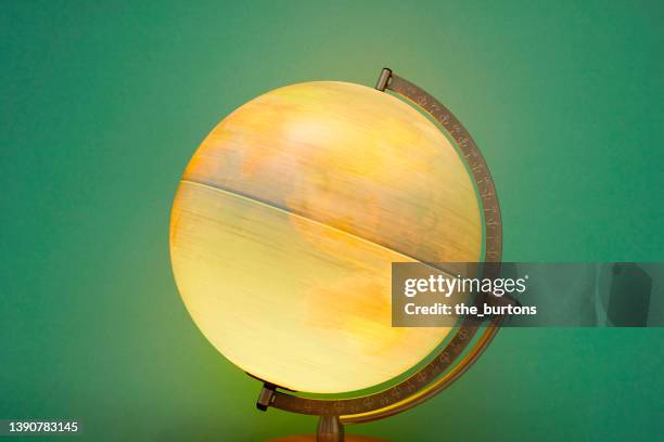 globe in motion against green background, map of asia and australia - globe man made object stock pictures, royalty-free photos & images