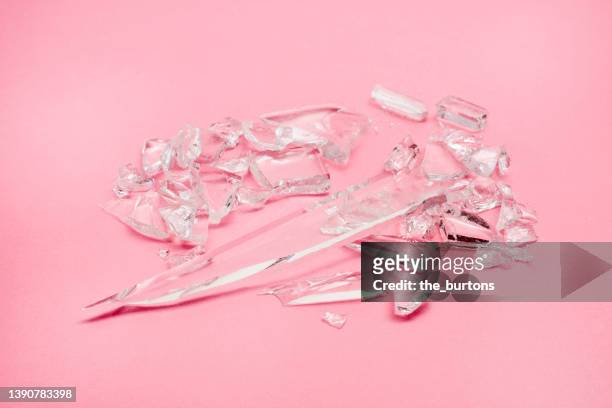 glass shards on pink background - 割れガラス ストックフォトと画像