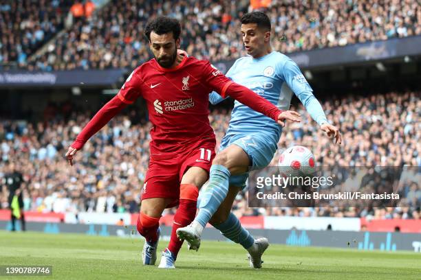 Joao Cancelo of Manchester City in action with Mohamed Salah of Liverpool during the Premier League match between Manchester City and Liverpool at...